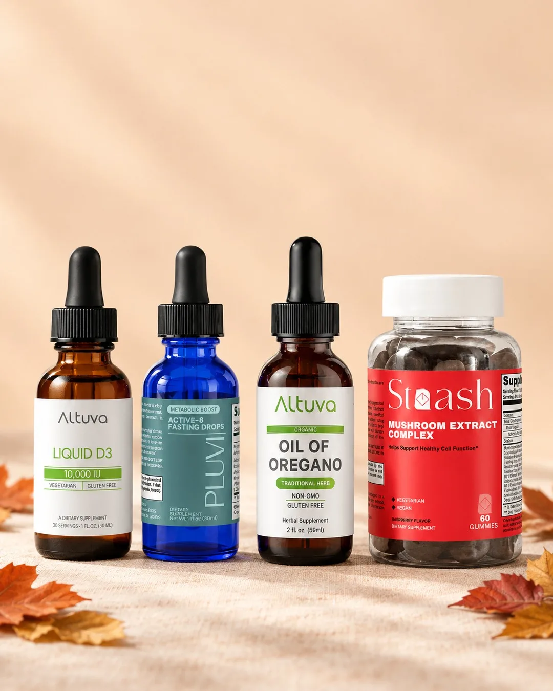 Liquid D3, Pluvi Active-8 Fasting Drops, Oil of Oregano and Mushroom Extract Complex on a fall table with autumn leaves.