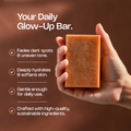 Hand holding a bar of soap with text about its benefits on a brown background